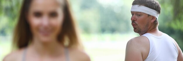 Young man looks at beautiful girl jogging closeup