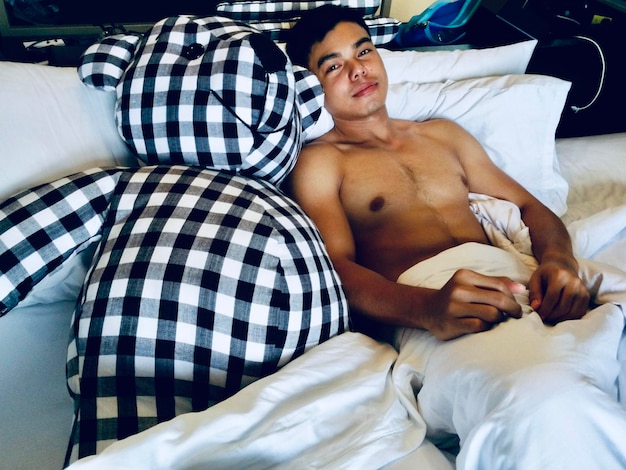 Photo young man lying on bed