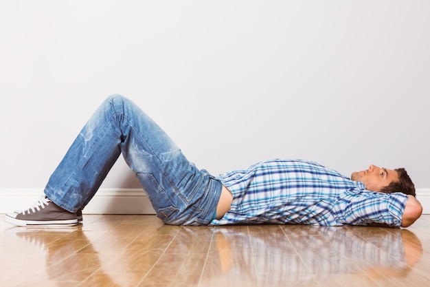 Young man lying on floor thinking