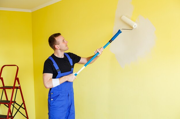 A young man makes repairs to the apartment, ok re-paints the\
walls in a different color