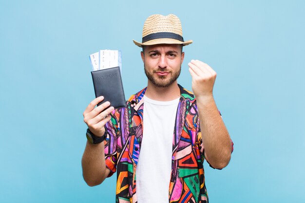 Young man making capice or money gesture, telling you to pay your debts!