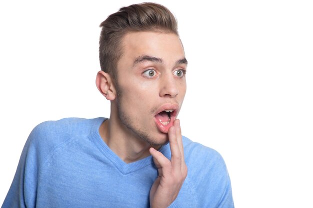 Young man making facial expression against white background