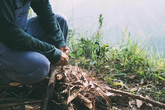 Young man making a fire in the forest