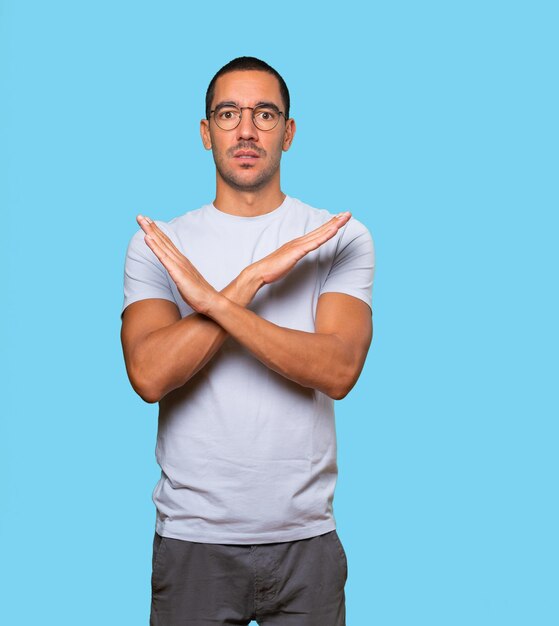 Photo young man making a gesture of not crossing with the arms