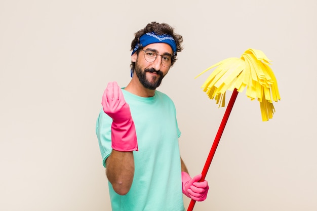 Young man making a money gesture holding a mop