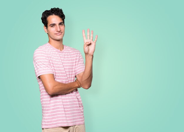 Young man making a number four gesture