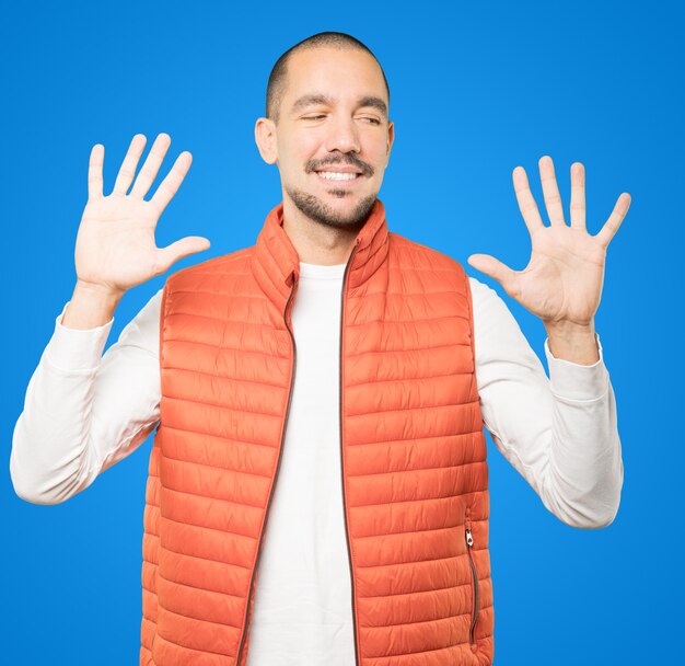 Young man making a number ten gesture