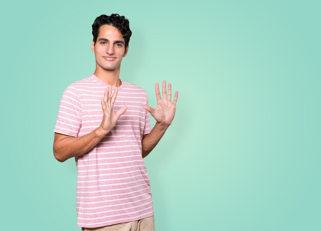 Young man making a number ten gesture