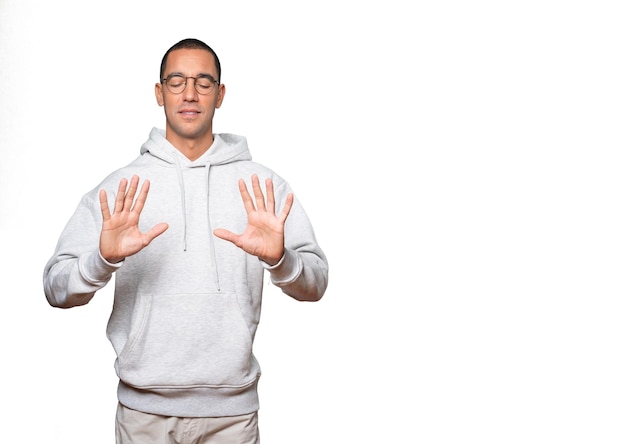 Young man making a number ten gesture