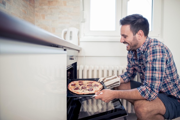 Photo young man making pizza