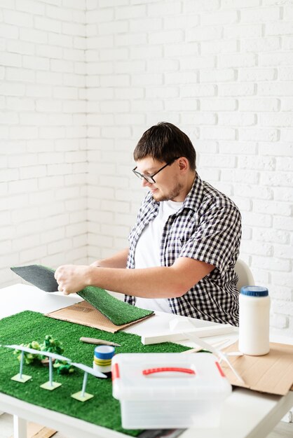 Young man making renewable energy project dummy