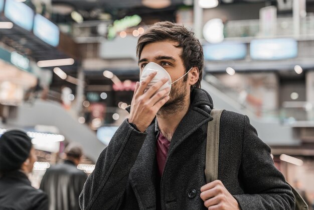 Young man in mask protects himself from the epidemic or air pollution in shopping center