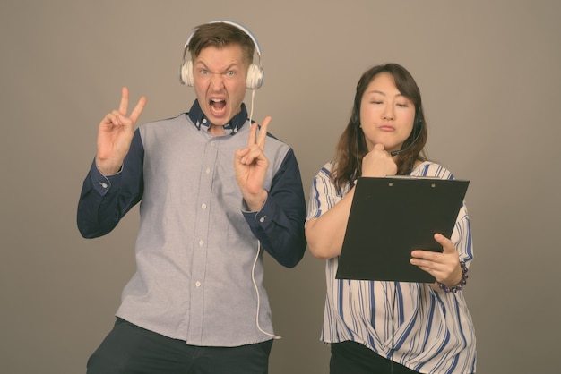 young man and mature asian woman on gray