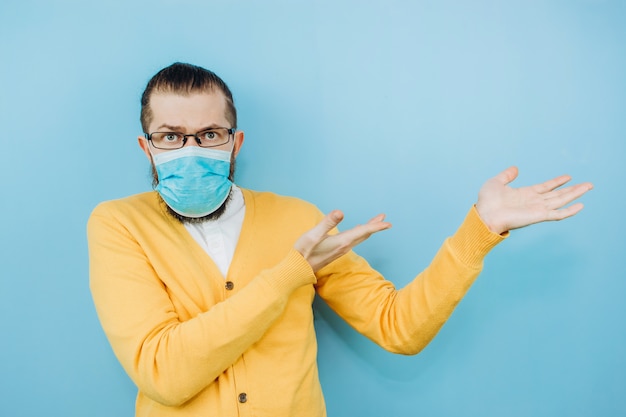 A young man in a medical mask on a blue