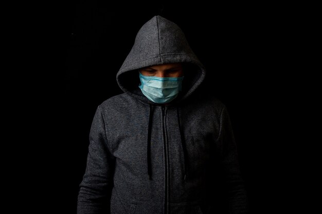 Young man in a medical mask and a hoodie