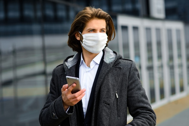 Young man in a medical mask outside