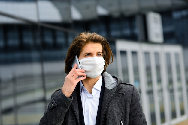 Young man in a medical mask outside