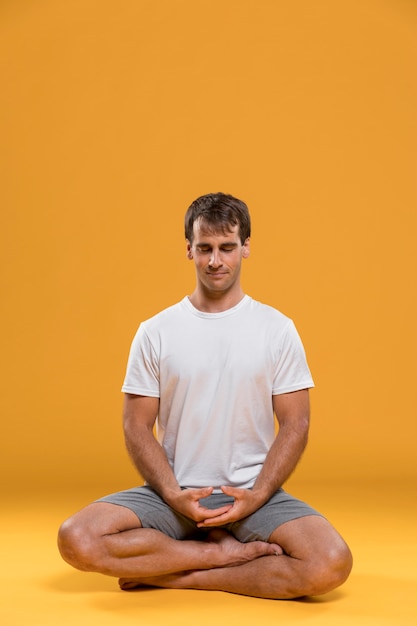 Photo young man meditating in lotus pose