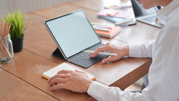 Young man meeting online and taking notes at his house