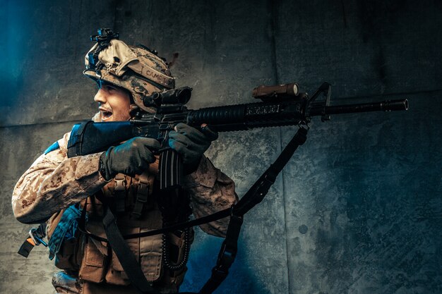 Young man in military outfit a mercenary soldier in modern times on a dark  in studio