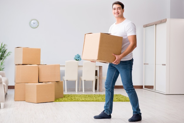 Young man moving boxes at home