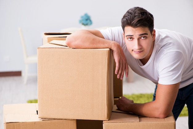 Young man moving boxes at home