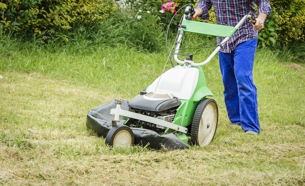 Young man mowing the lawn with a lawnmower