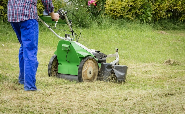 young man mowing the lawn with a lawnmower