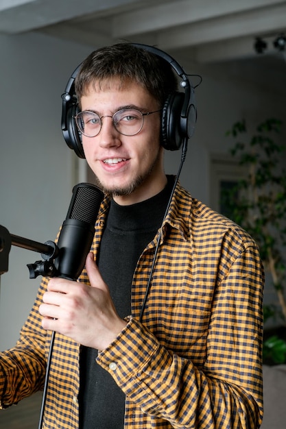 Young man musician singing song playing classical guitar at music studio Male wearing earphones