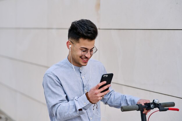 写真 電話で話しているスクーターの若い男