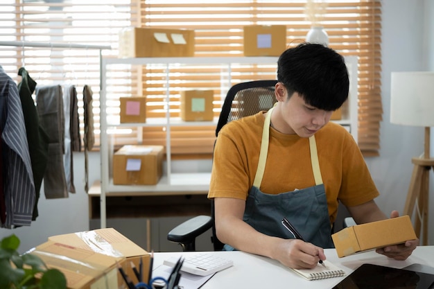 Young man online seller preparing package for delivery to costumer at is home office