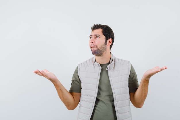 Young man opening his hands widely on white background