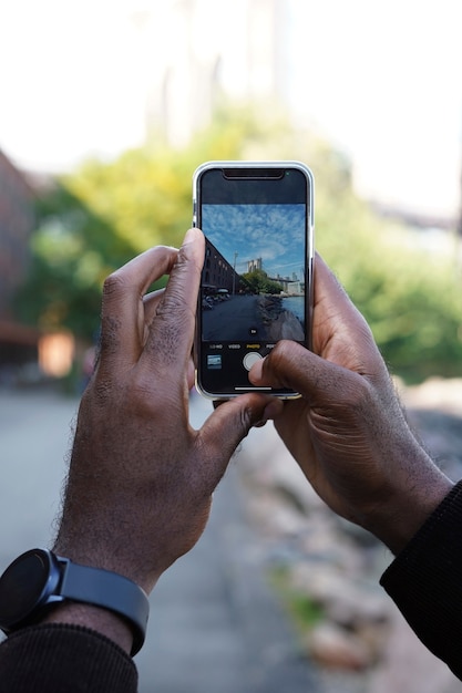 一人で街を探索し、スマートフォンで写真を撮る屋外の若い男