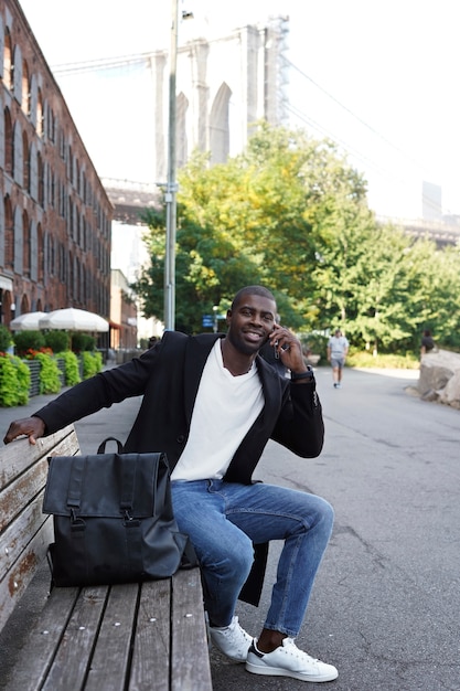 Photo young man outdoors exploring the city and using smartphone