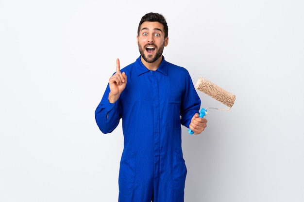 Young man in overalls holding a paint roller