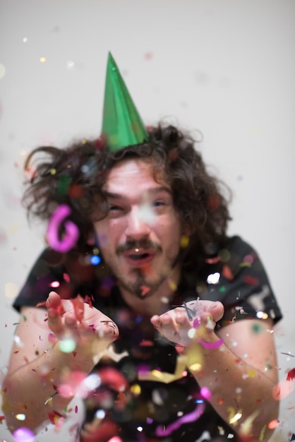 young man on party celebrating new year with falling confetti