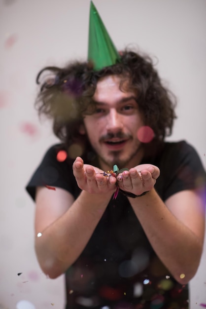 young man on party celebrating new year with falling confetti