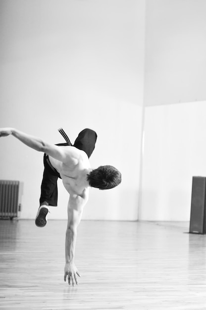 молодой человек исполняет брейк-данс в танцевальной студии