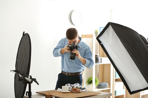 Young man photographing food in professional photo studio