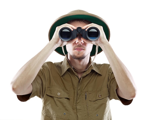 Young man in pith helmet looking through binoculars isolated on white