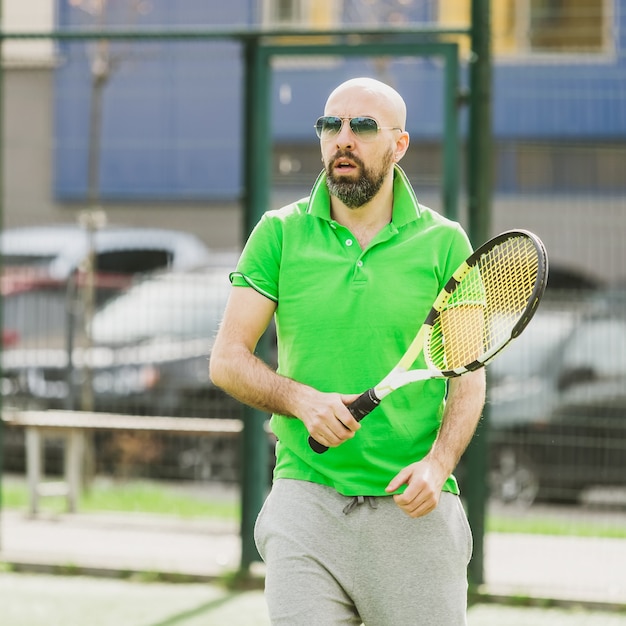 写真 若い男は早朝にテニスフィールドで屋外テニスをします