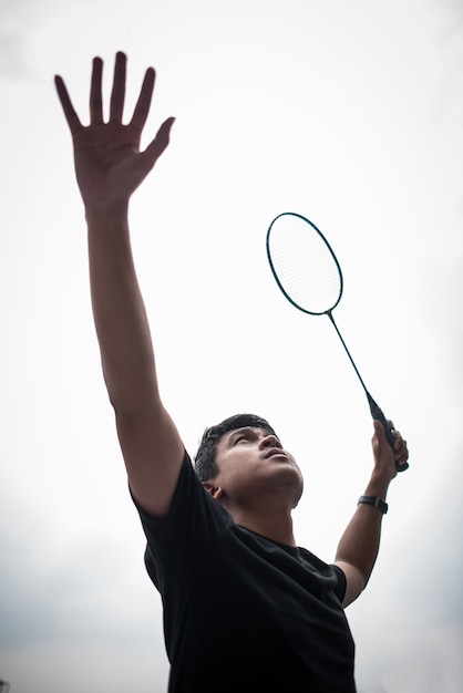 Young man playing badminton outdoors