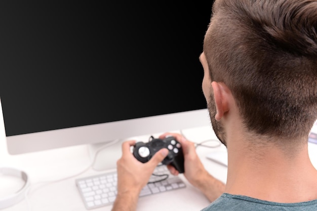 Фото Молодой человек играет в компьютерные игры дома