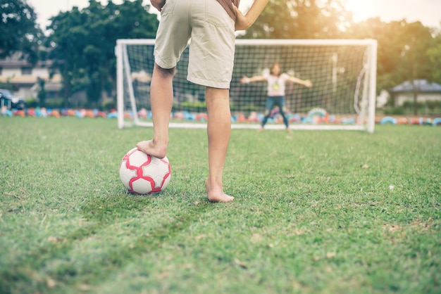 若い男はサッカーをする