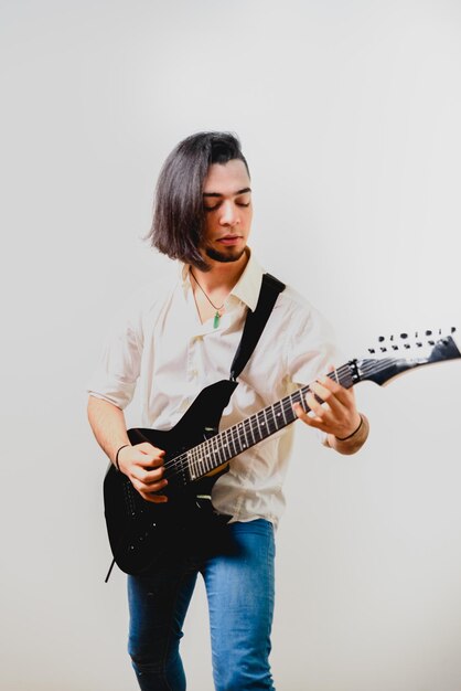 Foto giovane che suona la chitarra su uno sfondo bianco