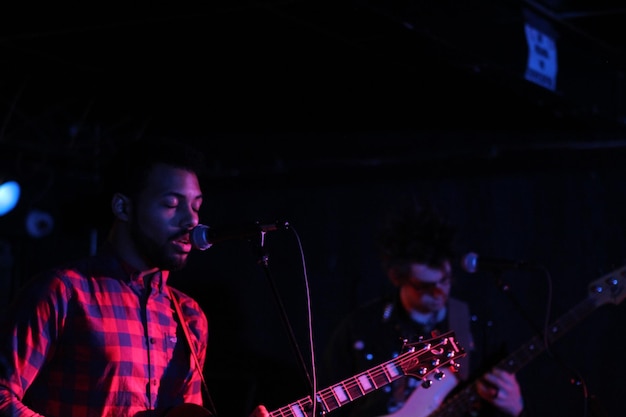 Photo young man playing guitar at music concert