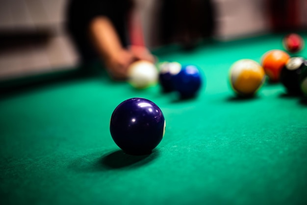 Young man playing snooker aiming for a good shot