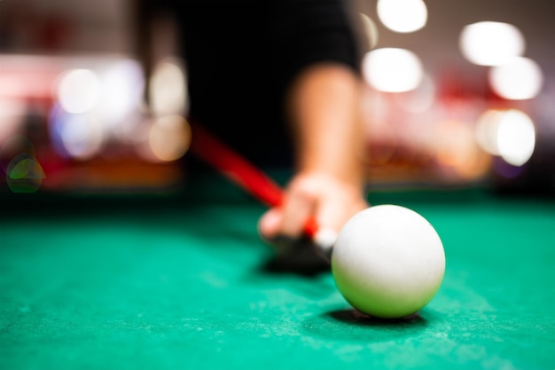 Young man playing snooker aiming for a good shot