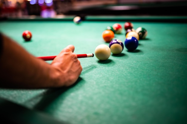 Young man playing snooker aiming for a good shot