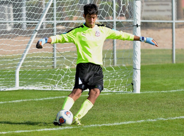 写真 フィールドでサッカーをしている若い男